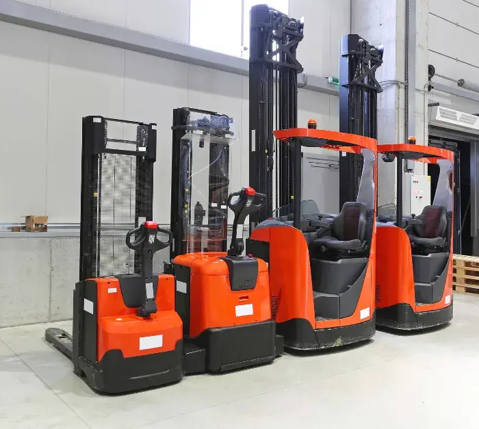 Three red and black forklifts are lined up in a warehouse, showcasing different models with varying heights, all conveying utility and efficiency.